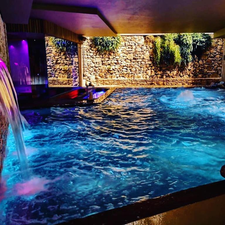 a swimming pool with a waterfall in a building at Gran Paradiso Hotel Spa in San Giovanni Rotondo