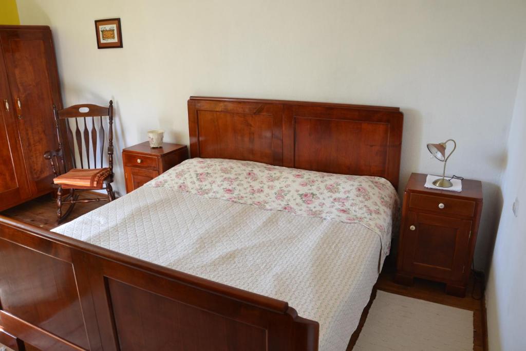 ein Schlafzimmer mit einem Holzbett und einem Stuhl in der Unterkunft Ostir Holiday Home in Cerknica