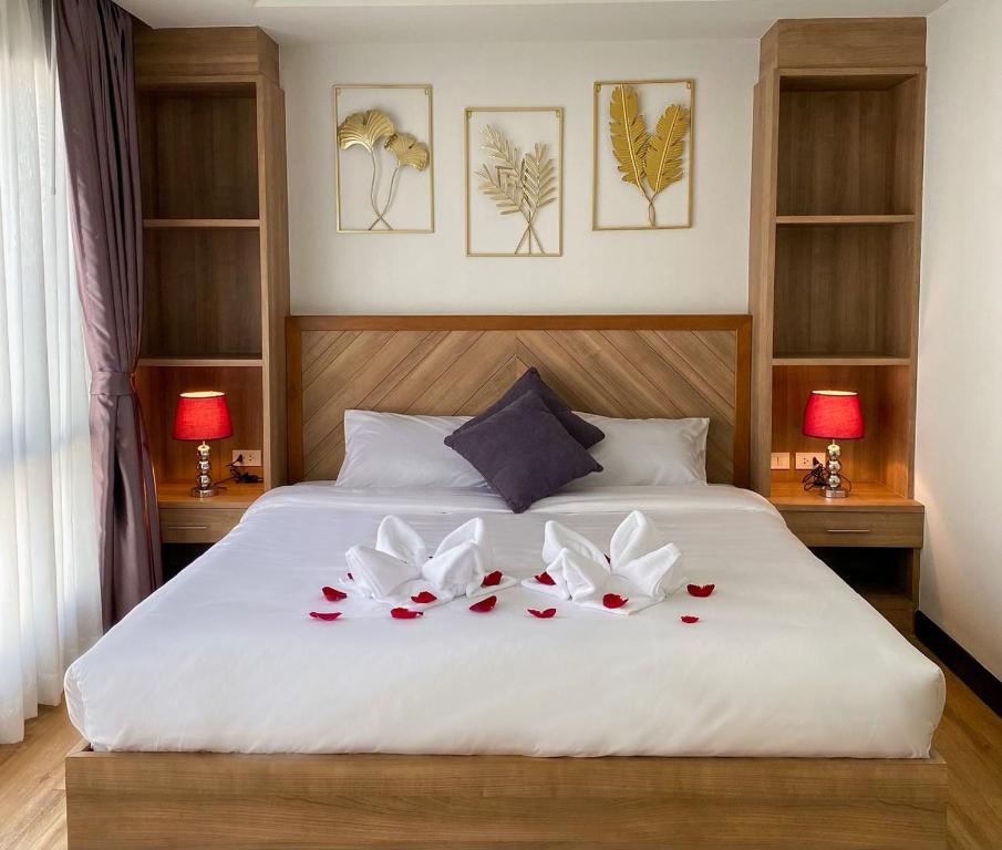 a bedroom with a white bed with flowers on it at DE LUXE BOUTIQUE & rooftop in Chiang Mai