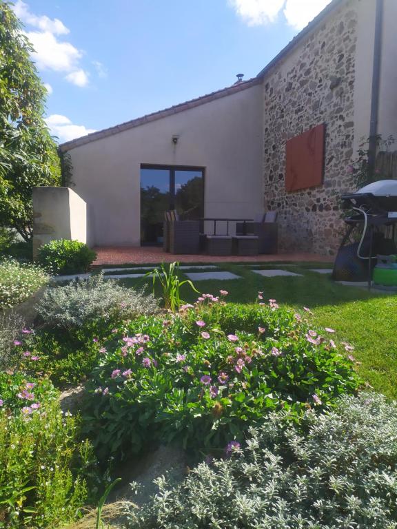 een tuin met bloemen voor een gebouw bij La Loge Bertine in Saint-Mars-la-Réorthe