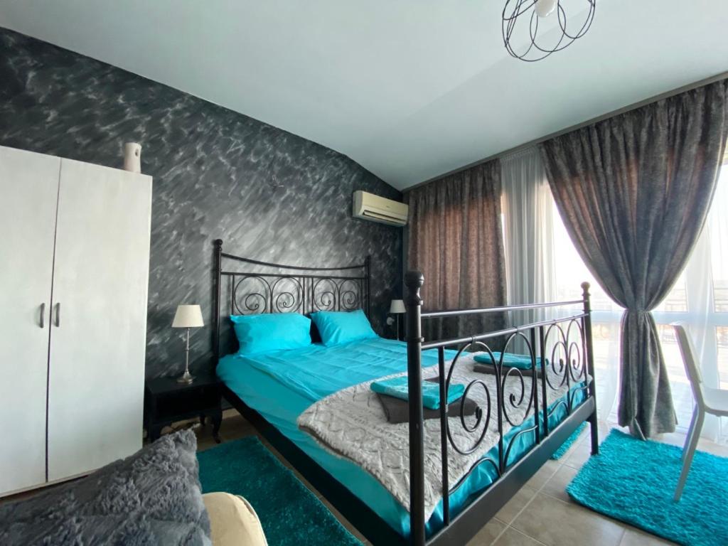 a bedroom with a bed with a blue bedspread at TOP SKY VIEW - Studio Panorama in Veliko Tŭrnovo