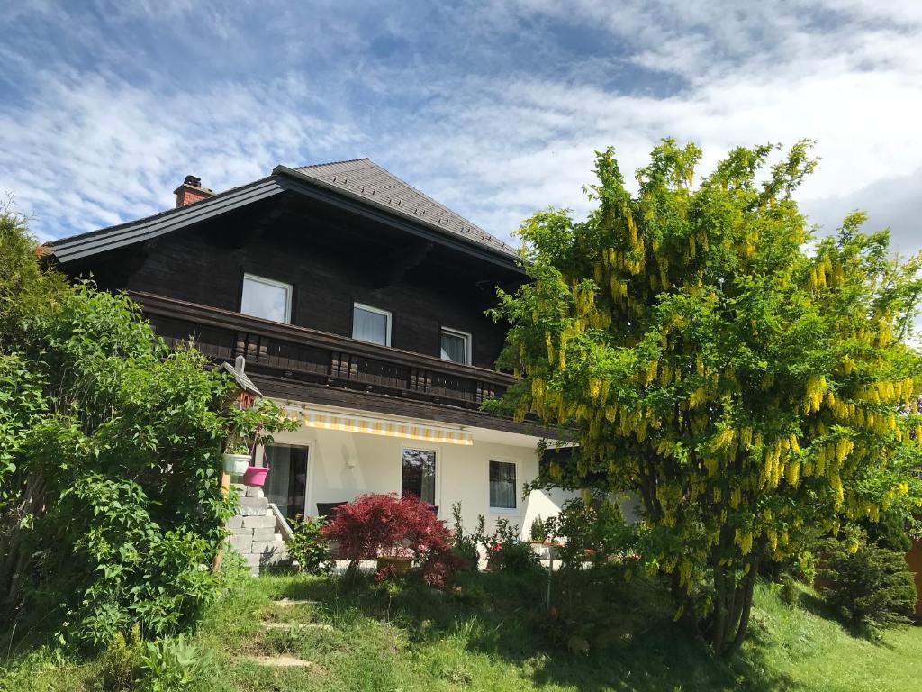 a black and white house with a tree at Ferienwohnung und Zimmer Kassar Bikertipp in Mauterndorf