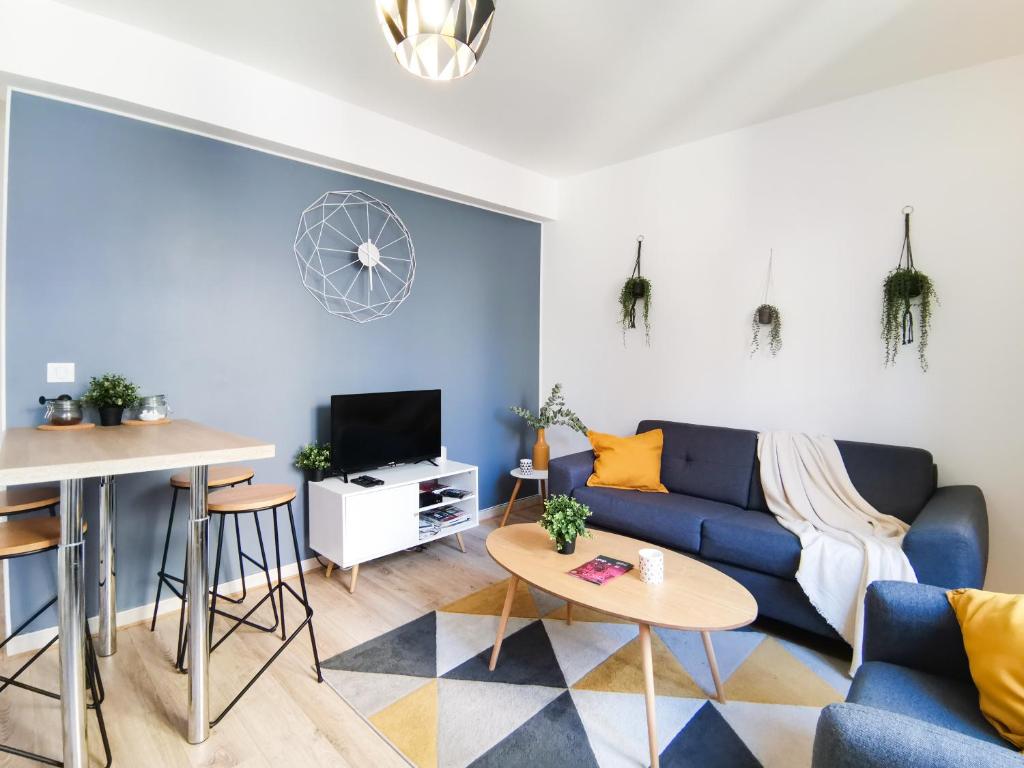 - un salon avec un canapé bleu et une table dans l'établissement Appartement calme en hypercentre, à Dijon