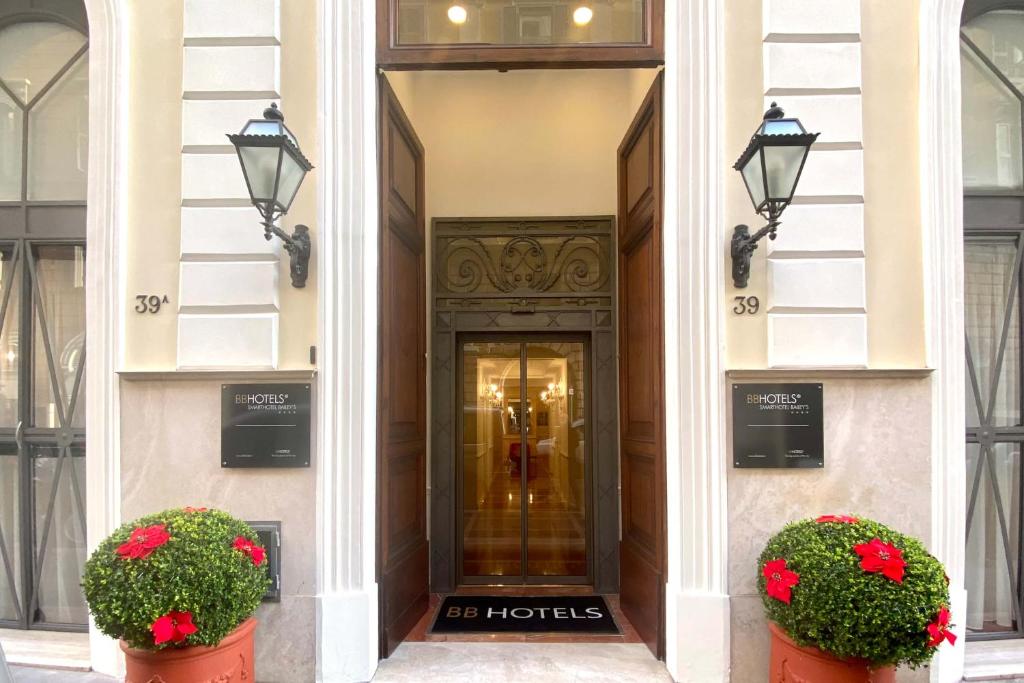 un edificio con una porta con dei fiori davanti di BB Hotels Smarthotel Bailey's a Roma