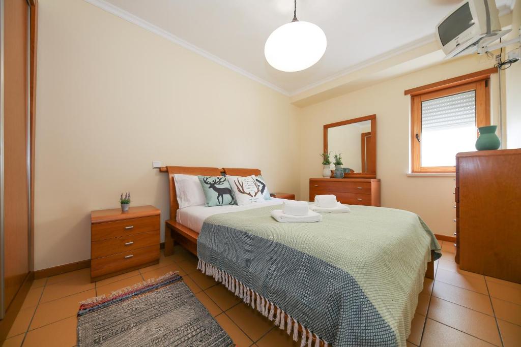 a bedroom with a bed and a television in it at Casa Marés in Nazaré