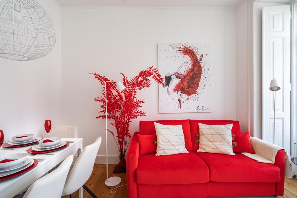 uma sala de estar com um sofá vermelho e uma mesa em Akicity Campolide Apollo em Lisboa