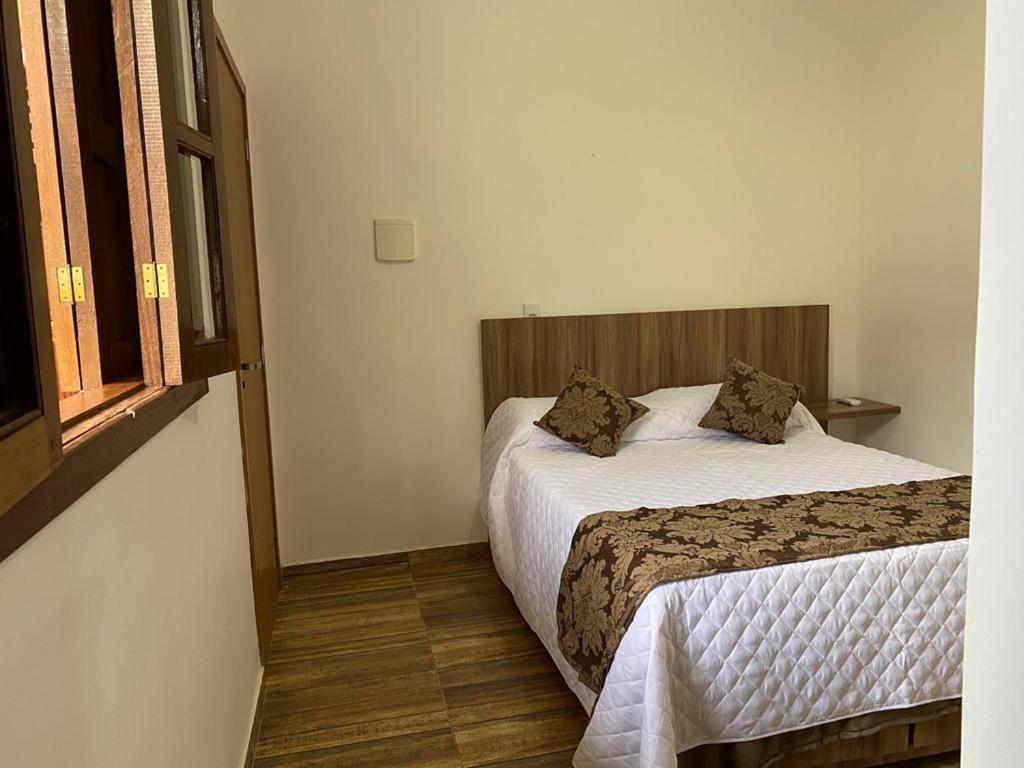 a hotel room with two beds and a window at Pousada da Villa in Sao Jorge