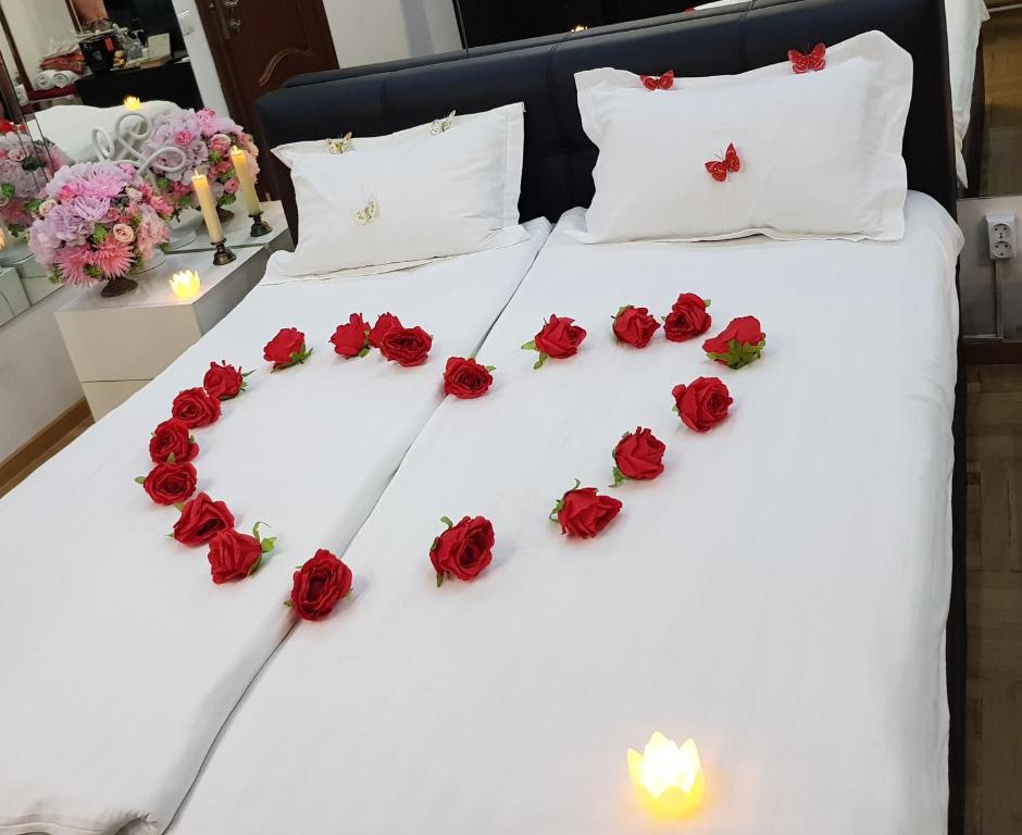 a bed with red roses arranged in the shape of a heart at Mirrors Room Mega Mall National Arena in Bucharest