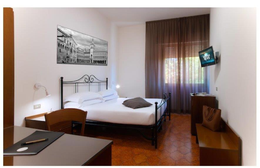 Łóżko lub łóżka w pokoju w obiekcie CDH Hotel Modena