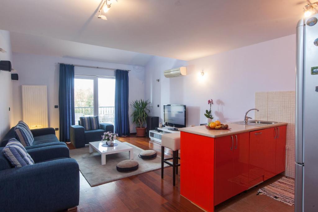 uma sala de estar com um sofá azul e um armário vermelho em Apartments Tino em Makarska