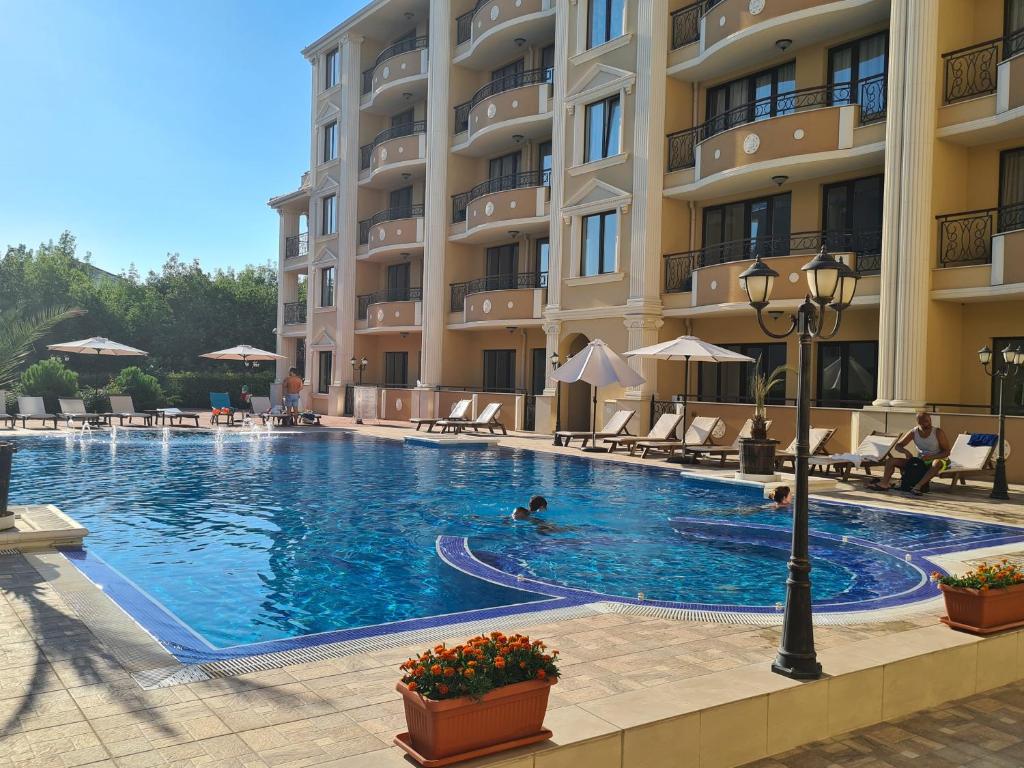 a large swimming pool in front of a building at Flora Beach Private in Pomorie