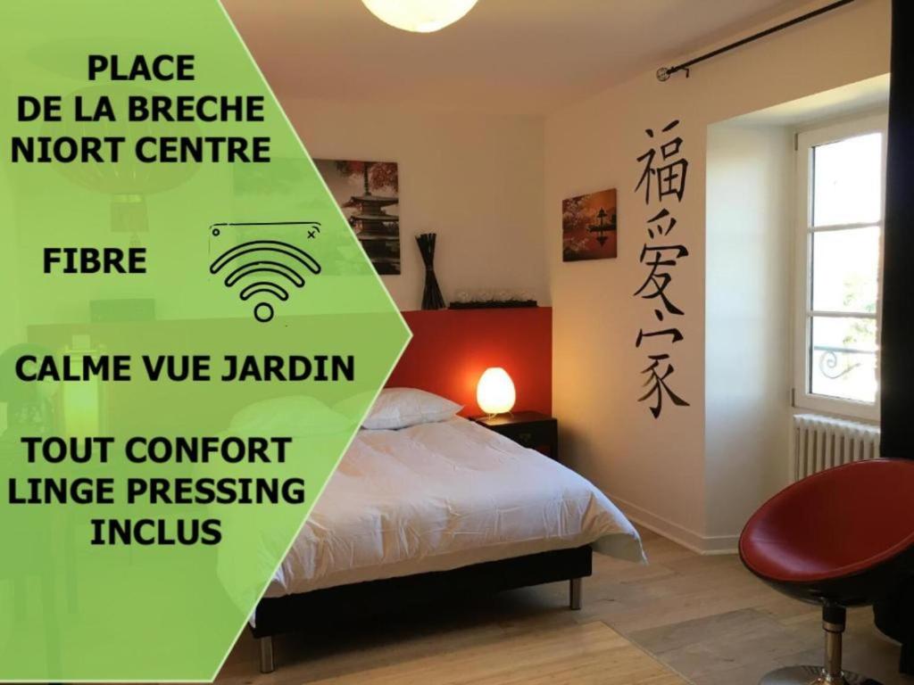 Cette chambre comprend un lit et un panneau. dans l'établissement Le Fuji centre la Brèche wifi calme vue jardin, à Niort