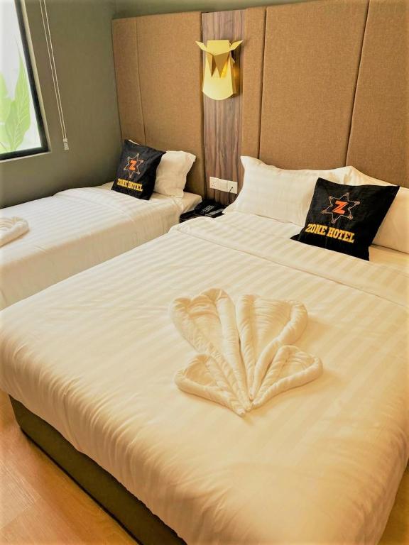 Postel nebo postele na pokoji v ubytování Zone Hotel Ipoh