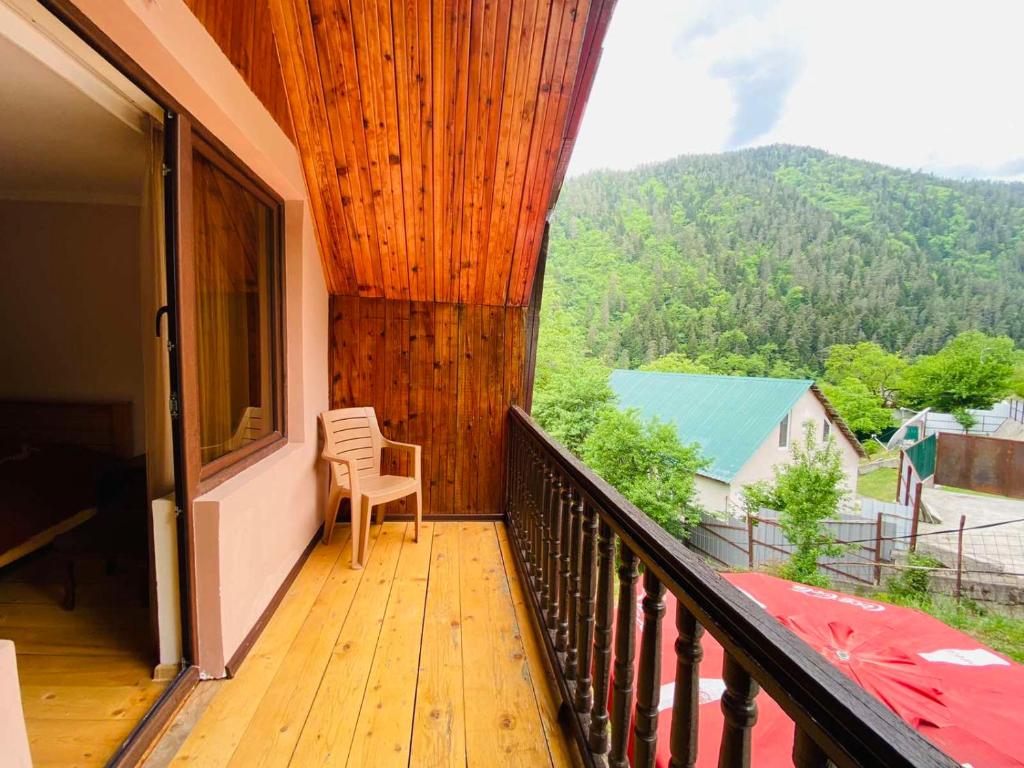 a balcony with a chair and a view of a mountain at Likani house in Borjomi