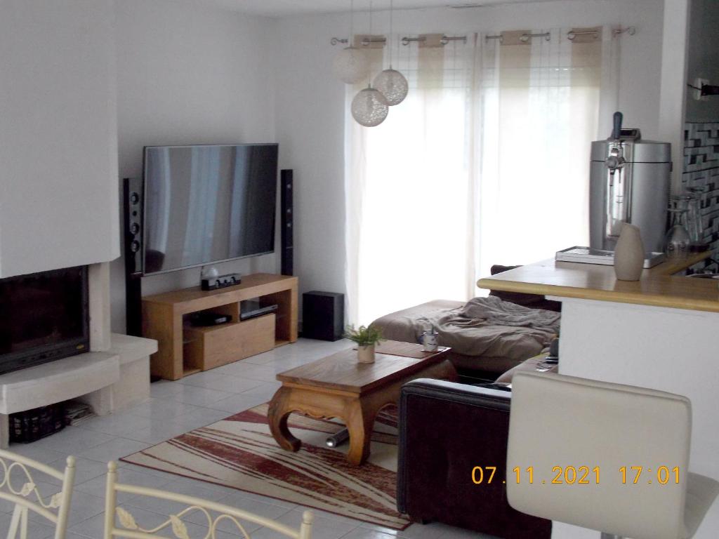 sala de estar con TV y mesa de centro en Maison de 3 chambres avec jacuzzi jardin amenage et wifi a Angoume, en Angoumé