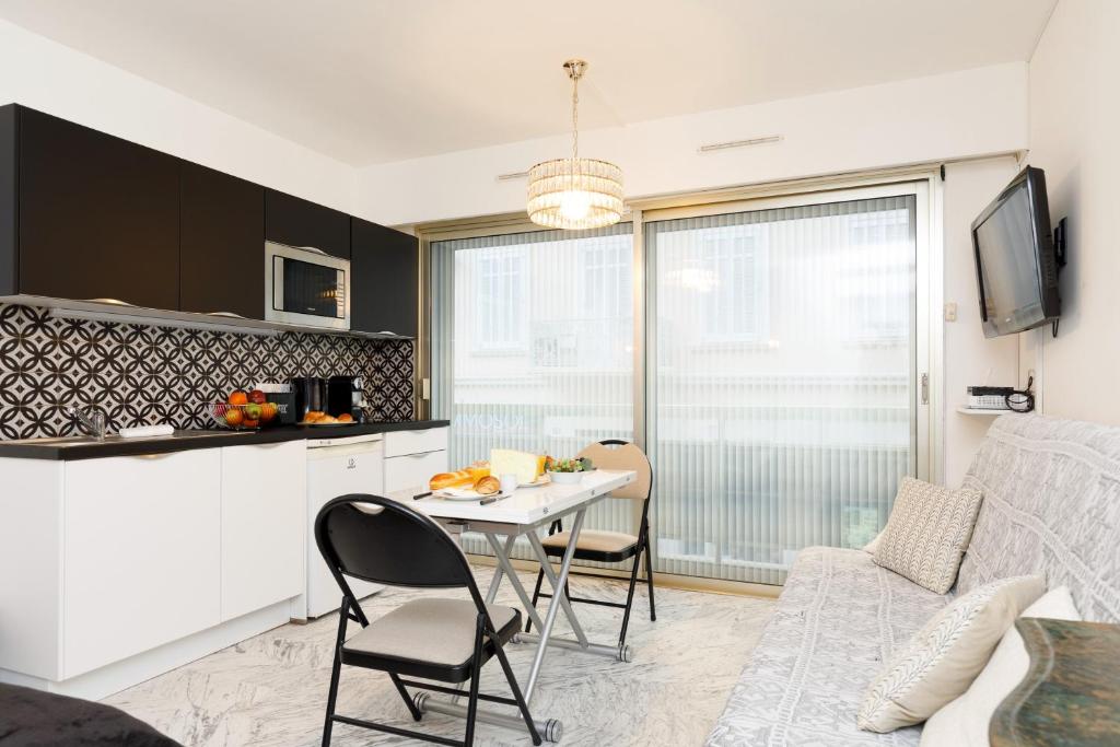 cocina y sala de estar con mesa y sillas en Le Minerve YourHostHelper, en Cannes