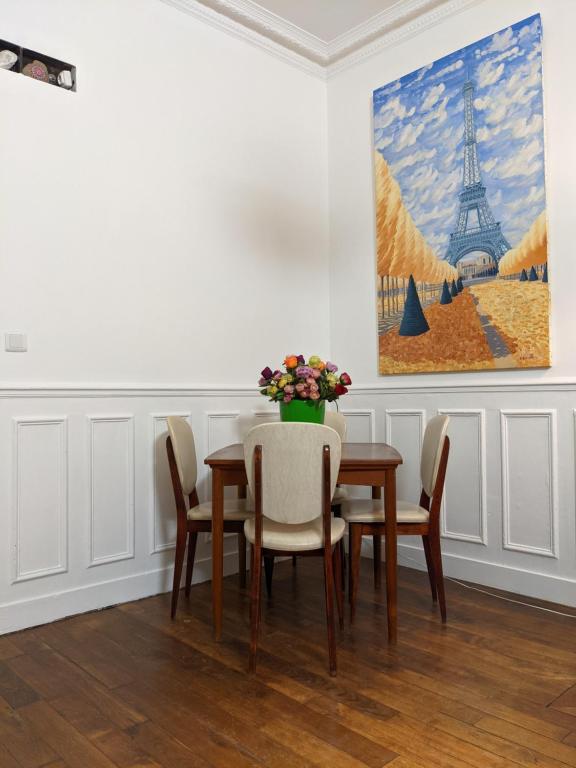 a dining room with a table and chairs and a painting at Private acces to the all flat. Charming Parisian. in Paris