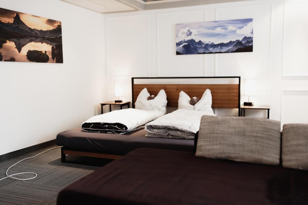 a bedroom with two beds and a couch at KemptenCityHost in Kempten