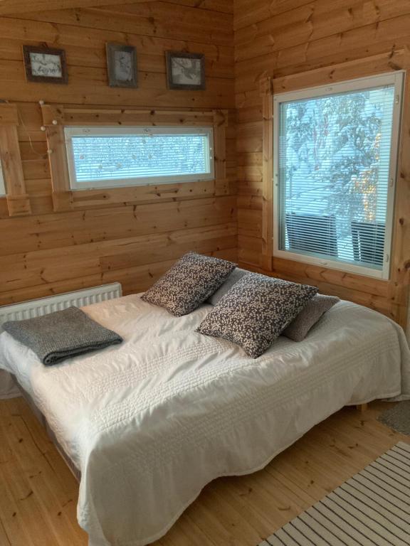a bedroom with a bed in a log cabin at Villa Kaltio in Äkäslompolo