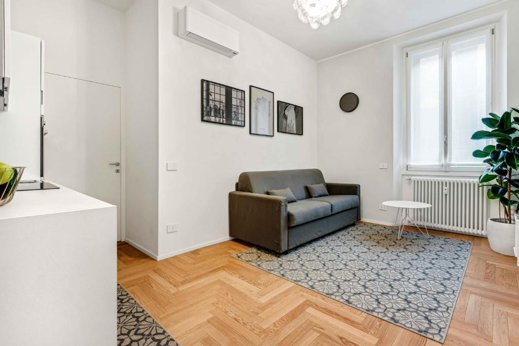 a living room with a leather chair and a table at New Milan Central Apartment in Milan