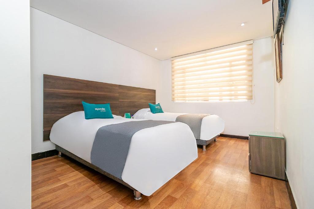 1 dormitorio con 2 camas y ventana en Ayenda 1079 Bogotá Alpes Polo Club, en Bogotá