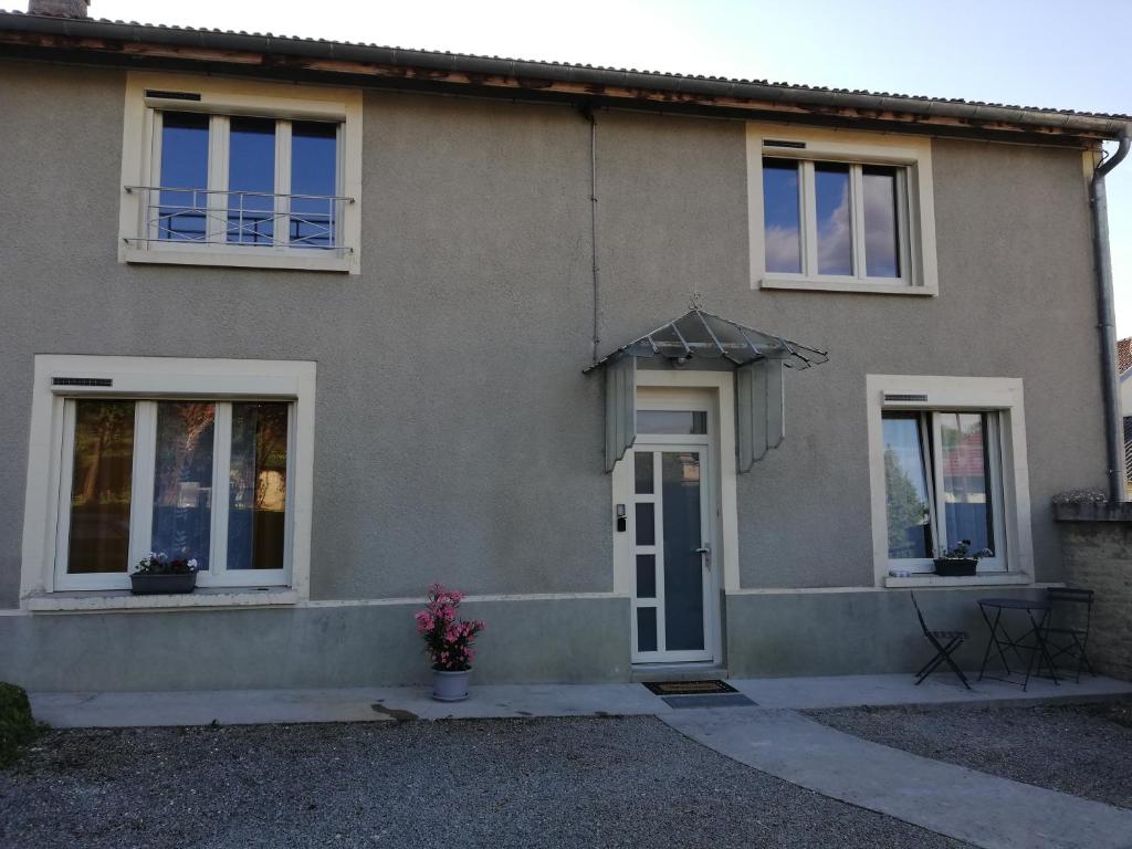una casa gris con puerta y ventanas en Gîte du capitaine, en Maranville