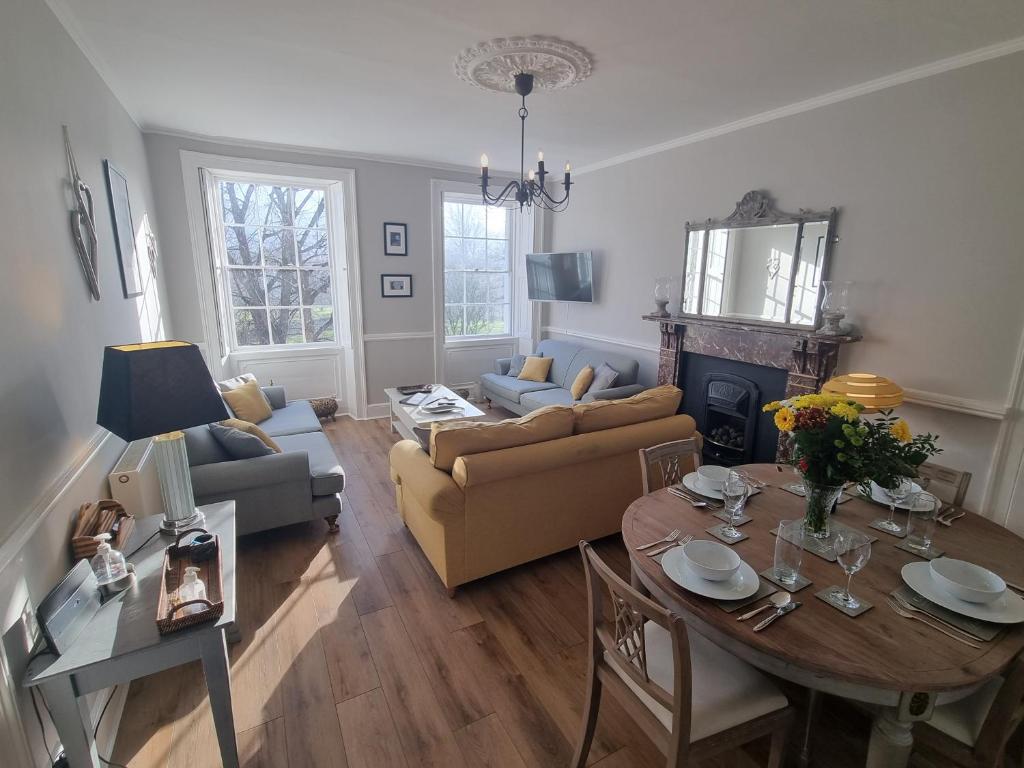 a living room with a table and a couch at Park View Two-Bedroom Apartment in Bath