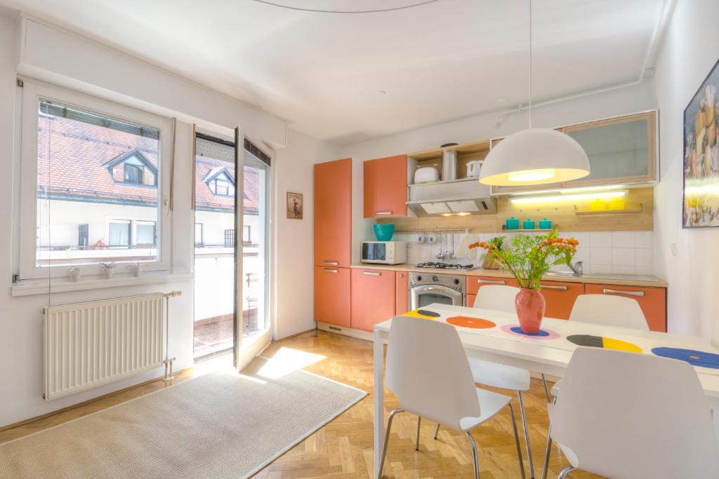 eine Küche und ein Esszimmer mit einem Tisch und Stühlen in der Unterkunft Apartments Fine Ziherlova in Ljubljana