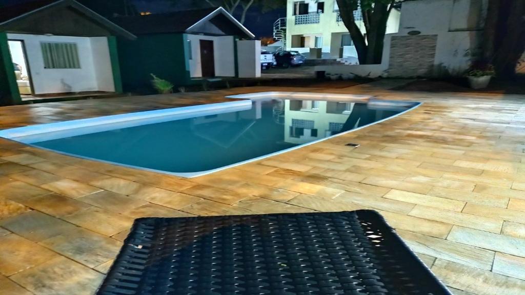 a swimming pool with a bench in a yard at Pousada Recanto das Maritacas in Brotas