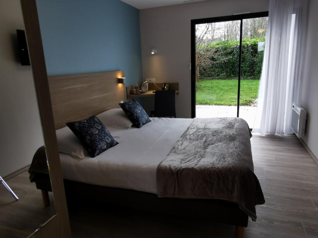 ルヴィルにあるHotel au Moyne De Saireのベッドルーム(大型ベッド1台、大きな窓付)