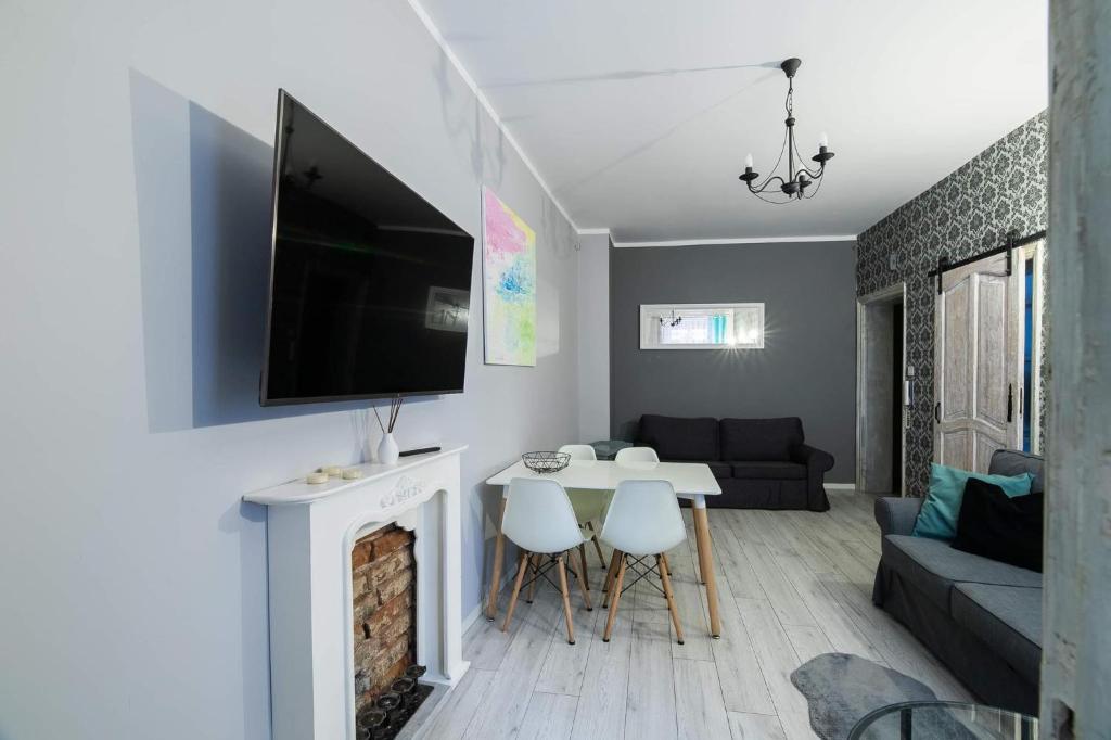 Televízia a/alebo spoločenská miestnosť v ubytovaní Apartament Zacisze