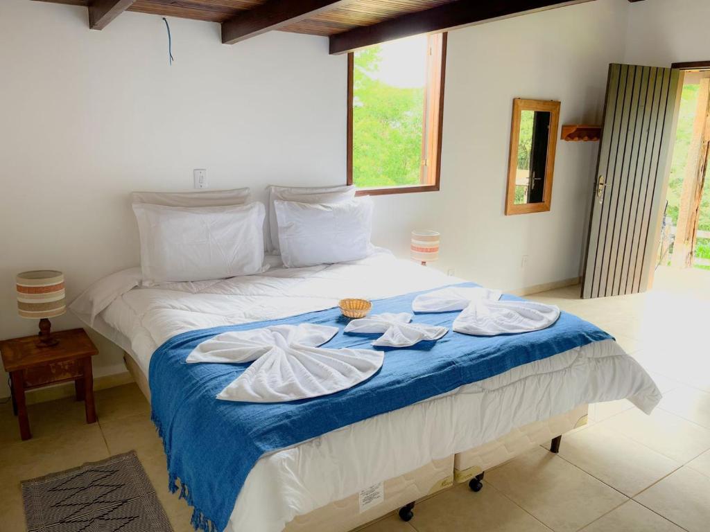a bedroom with a bed with two towels on it at POUSADA PÔR DO SOL in Ipiabas