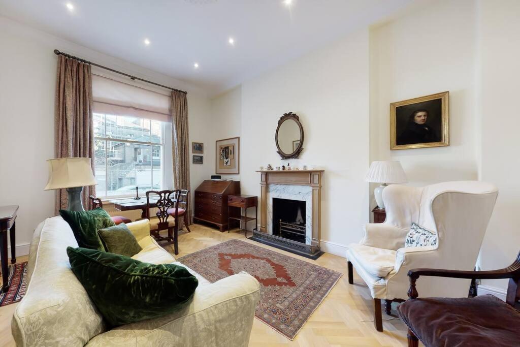 uma sala de estar com um sofá e uma lareira em Lovely 1 bedroom flat in Pimlico em Londres