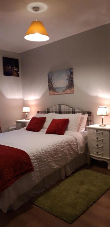 1 dormitorio con 1 cama blanca grande con almohadas rojas en Ashling B&B Ardara on Wild Atlantic Way F94T6N7, en Ardara