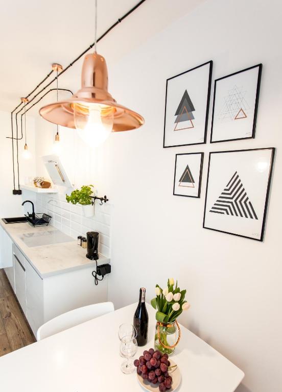 a kitchen with a white counter and a light fixture at Check in Szczecin in Szczecin