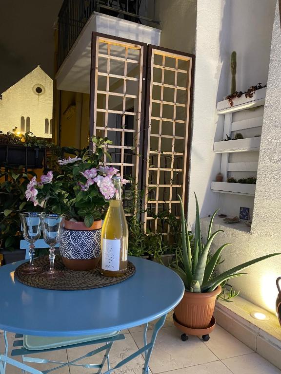 niebieski stół z butelką wina i roślinami w obiekcie Arco di Levante w mieście Bari