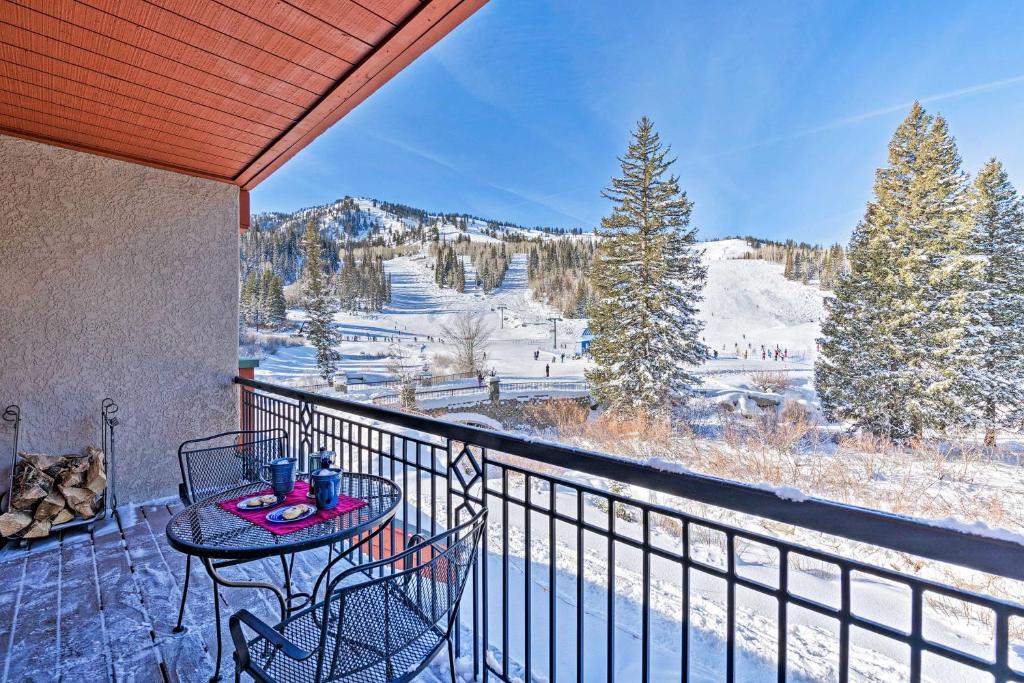 a balcony with a table and chairs and snow covered mountains at Solitude Creekside Condo-Closest to Ski Lift! in Solitude