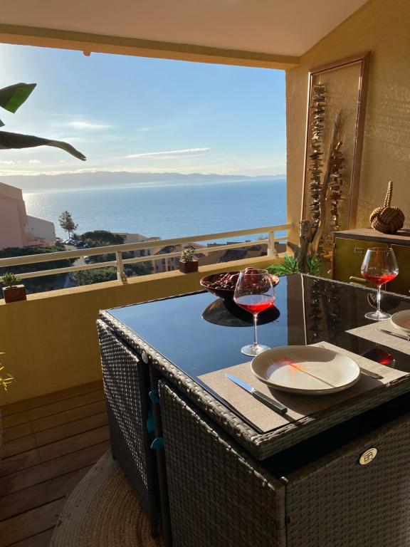 een tafel met twee glazen wijn op een balkon bij AJACCIO Très beau T2 confortable Sanguinaires in Ajaccio