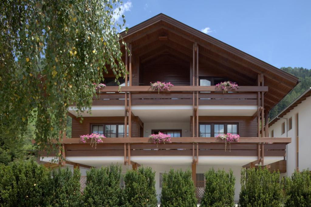 a building with pink flowers on the balconies at Dependance Villa Calluna in Campo Tures