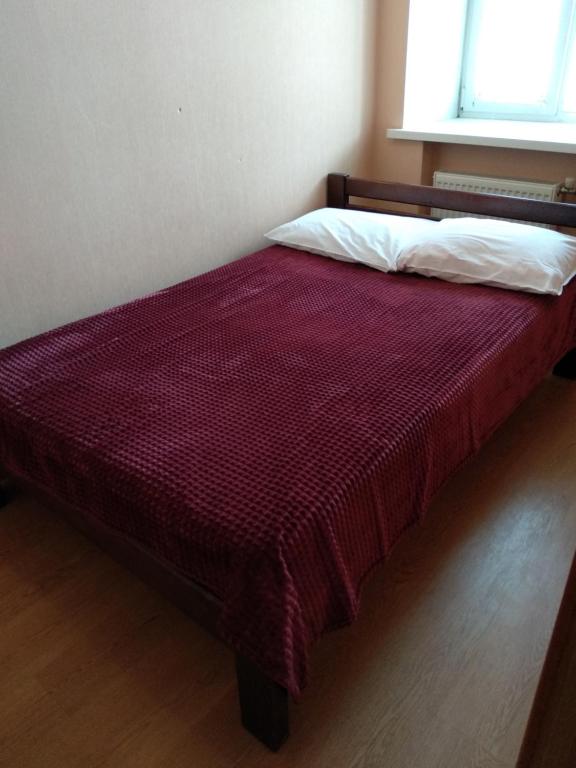 a bed with a red comforter in a room at 2-x Apartments Center Wi-Fi около Площади in Chernihiv