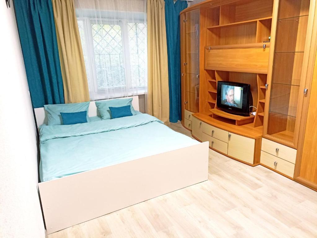 1 dormitorio pequeño con 1 cama y TV en Светлые апартаменты в 100м от Софиевского парка, en Uman