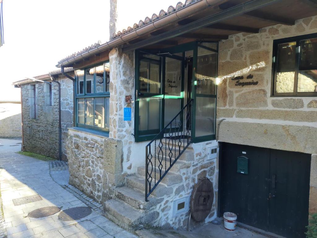 Edificio de piedra con puerta y balcón en Casa do sequeiro, en Parada del Sil