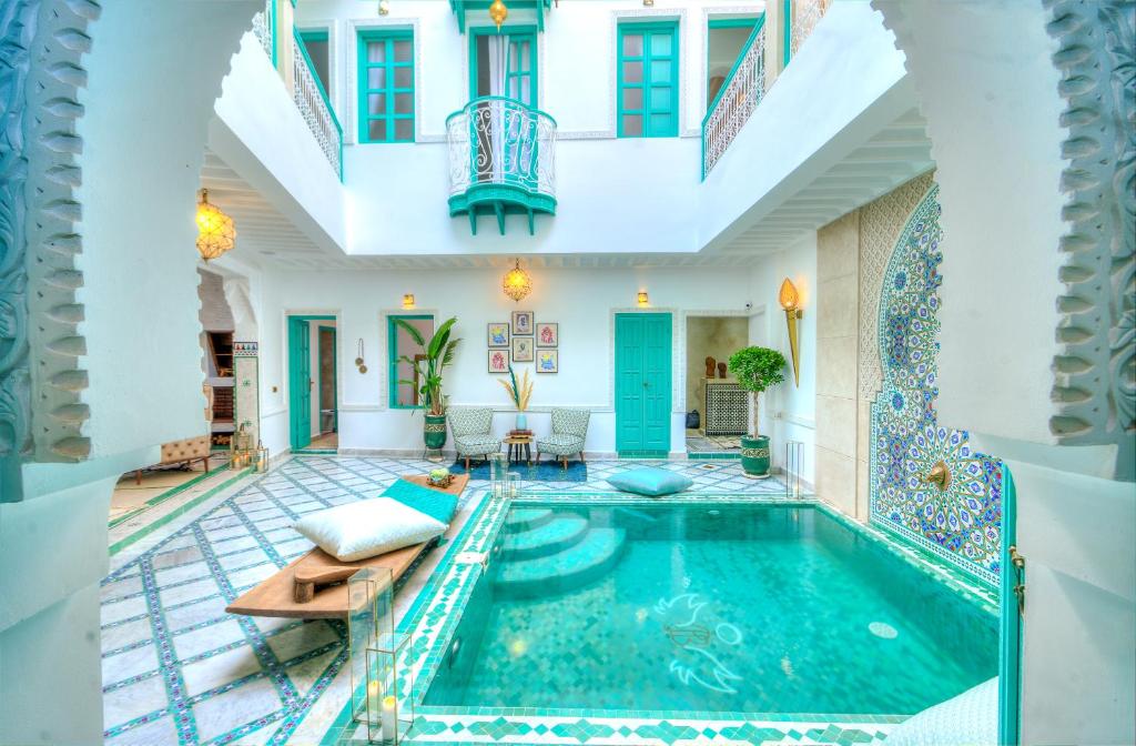 a swimming pool in the middle of a house at riad paradis blanc in Marrakech