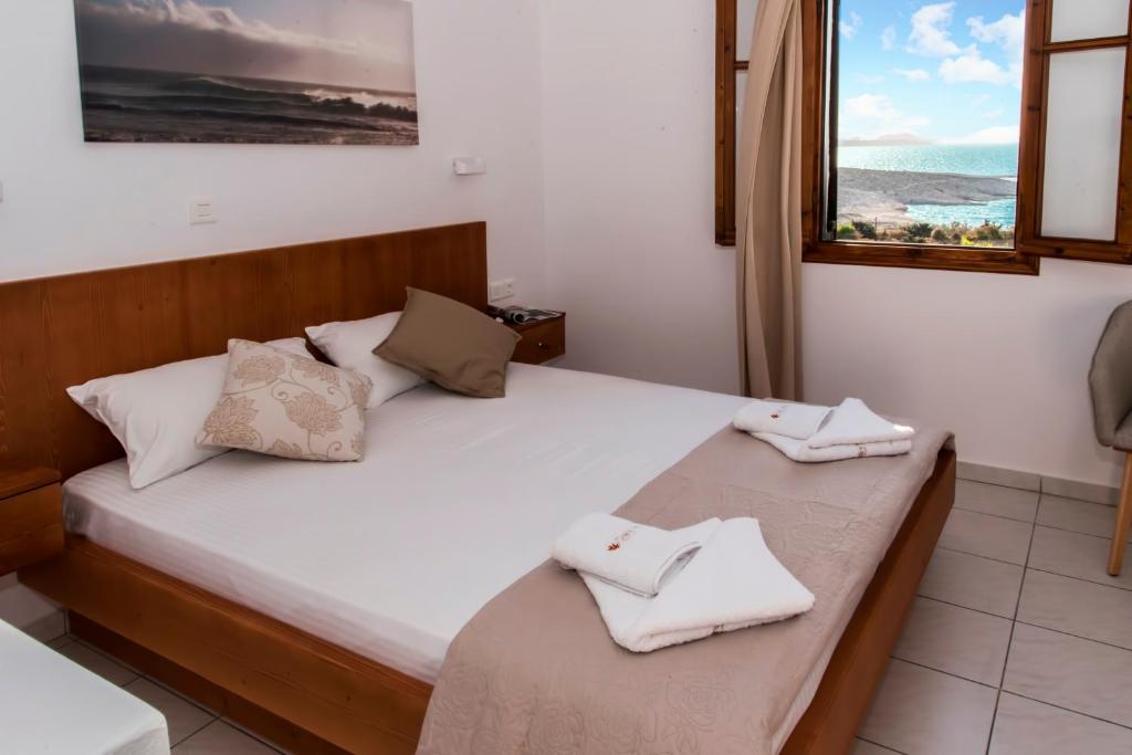 a bedroom with a bed with two towels on it at Galini in Agia Irini Milos