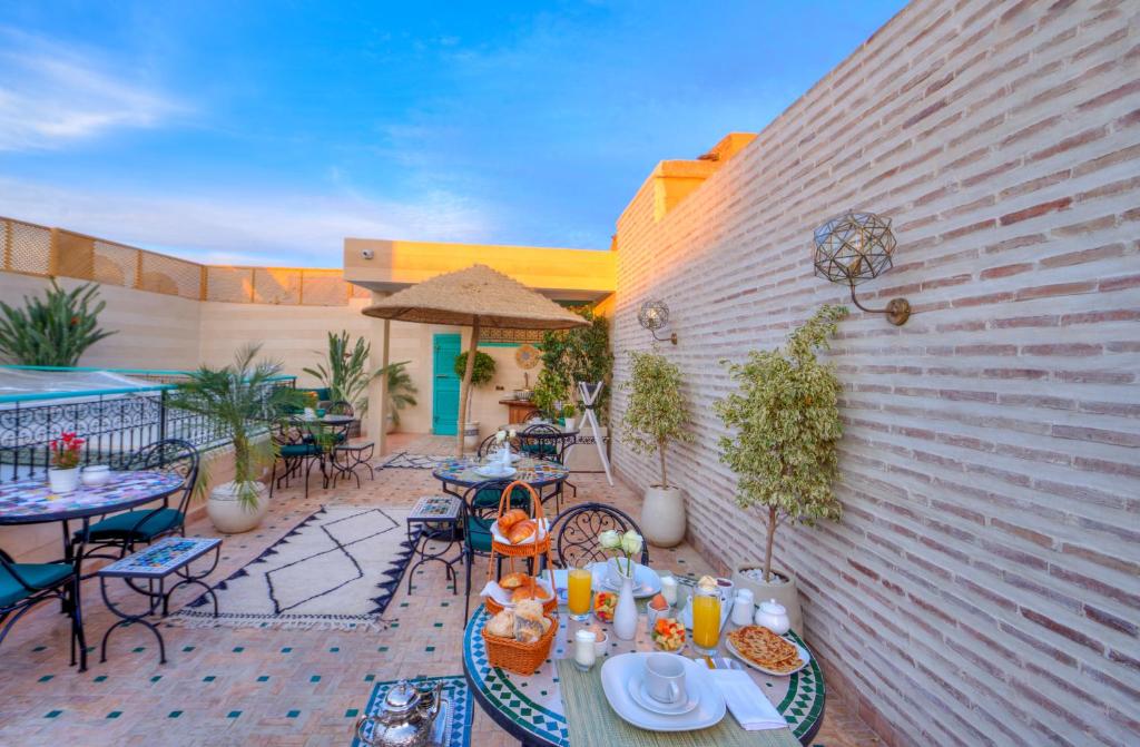 eine Terrasse mit einem Tisch mit Essen darauf in der Unterkunft riad paradis blanc in Marrakesch