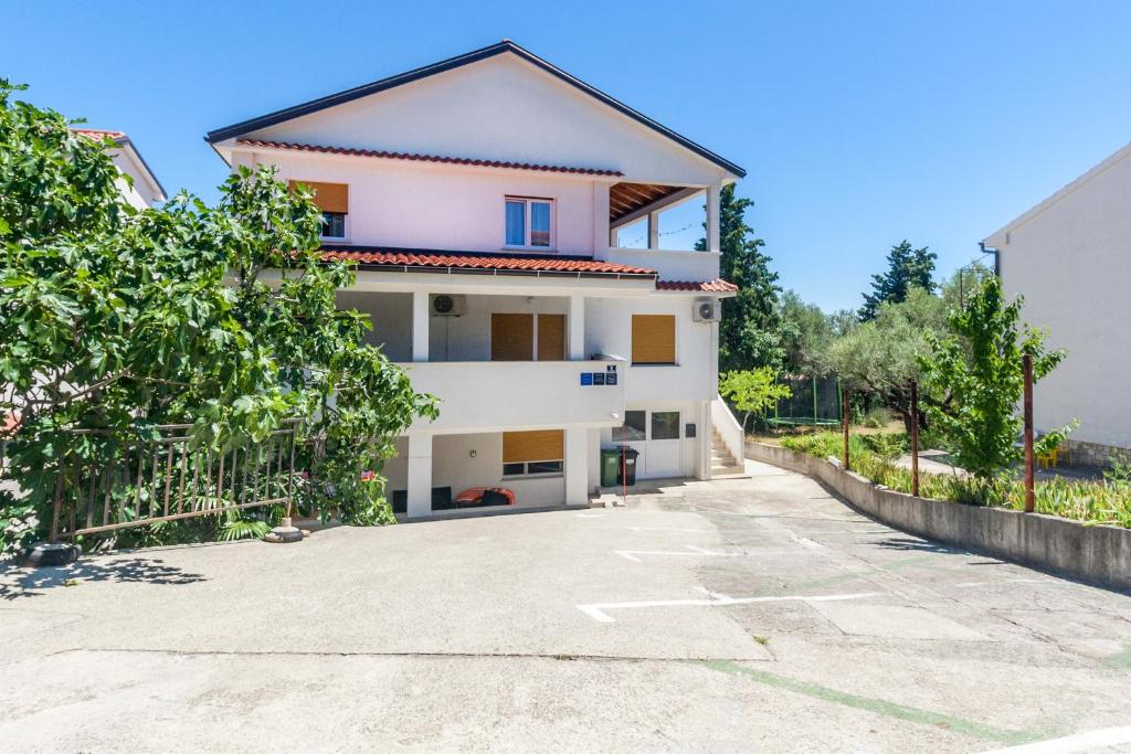 a house with a driveway in front of it at Apartments & Rooms Strčić Krk in Krk