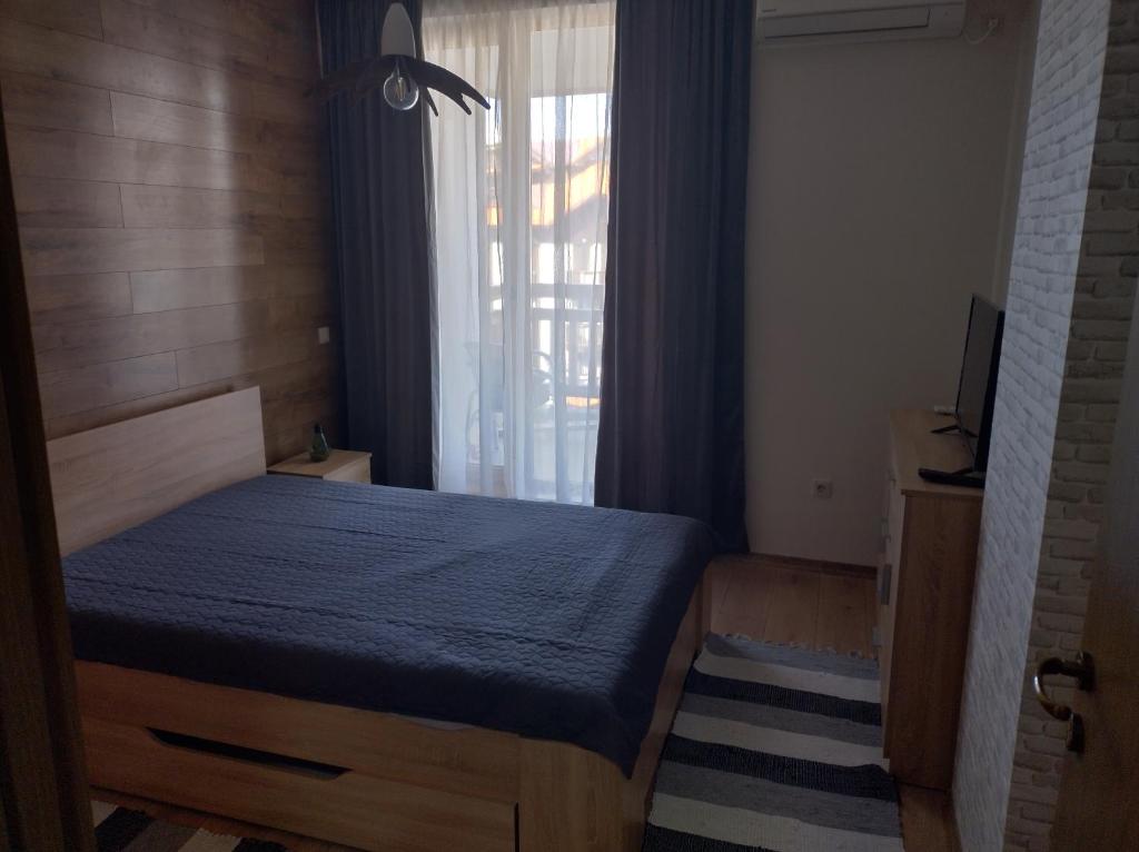 a bedroom with a blue bed with a window at St John Park Boutique room Gero in Bansko