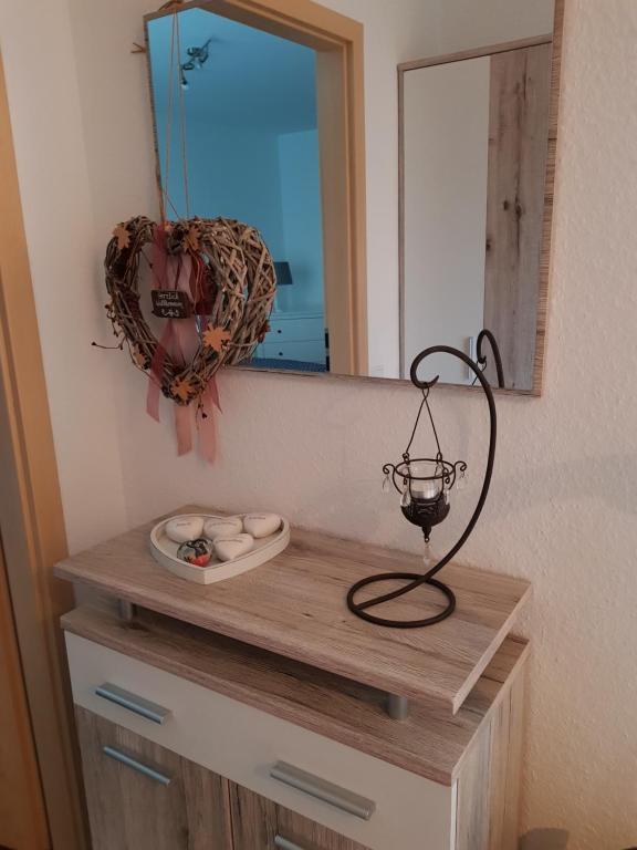 a wooden dresser with a mirror and a lamp on it at Lavendel in Bornheim