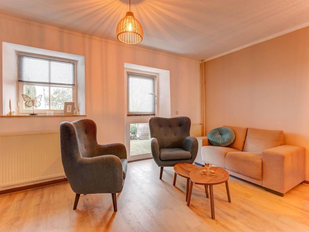 a living room with a couch and two chairs and a table at Beautiful holiday home in Voerendaal in Voerendaal