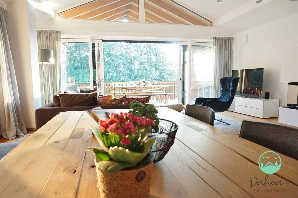 a living room with a wooden table with flowers on it at Purer Luxus am Samerberg mit Sauna & Kamin in Samerberg